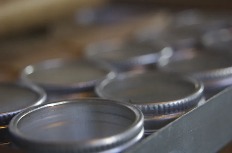 Several stainless steel frying pans arranged side by side