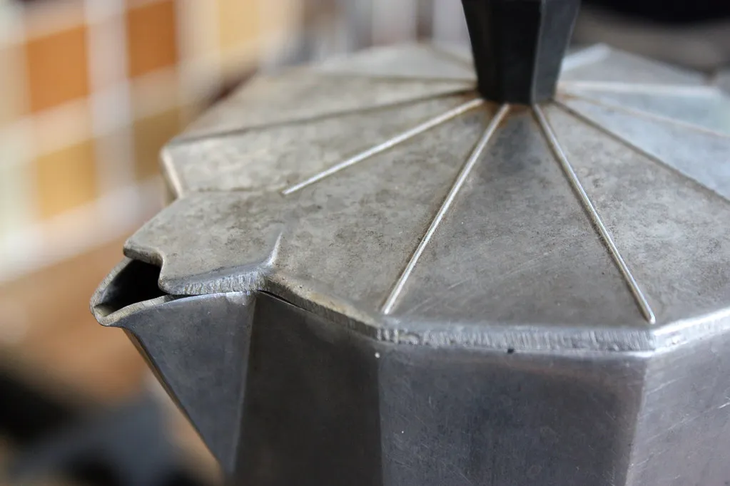 Close-up of the lid and spout of a metal moka pot