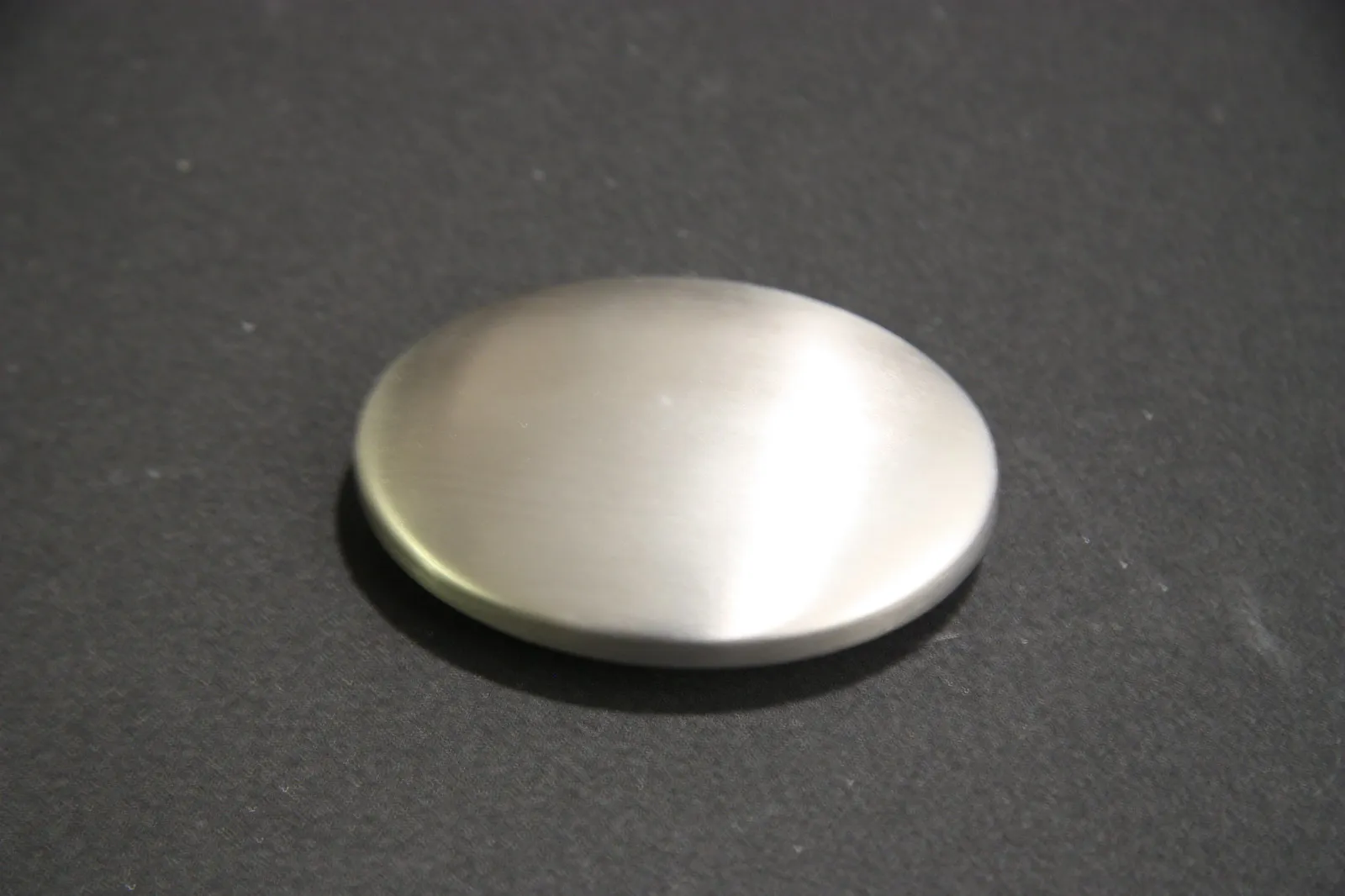 Rubbing hands against a stainless steel soap bar under a kitchen faucet