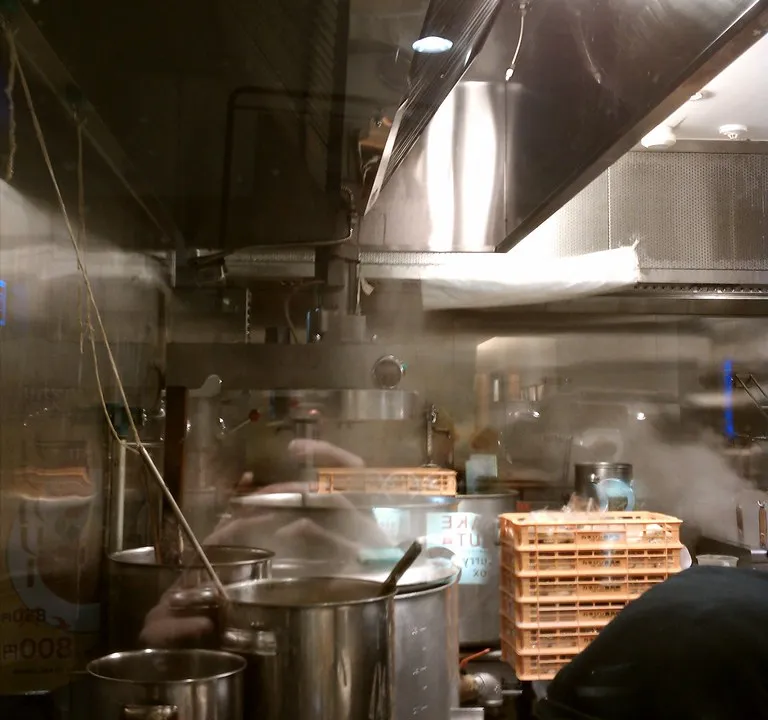 Stainless steel pots and pans in a working commercial kitchen