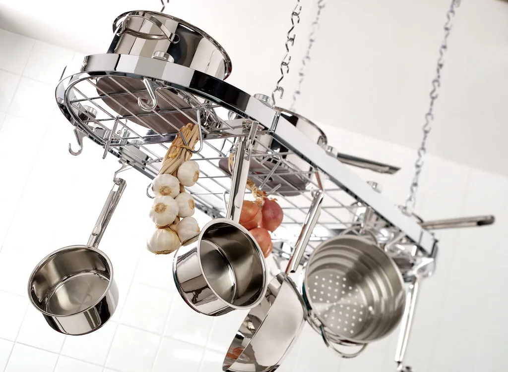 Polished stainless steel pots and pans arranged in a kitchen