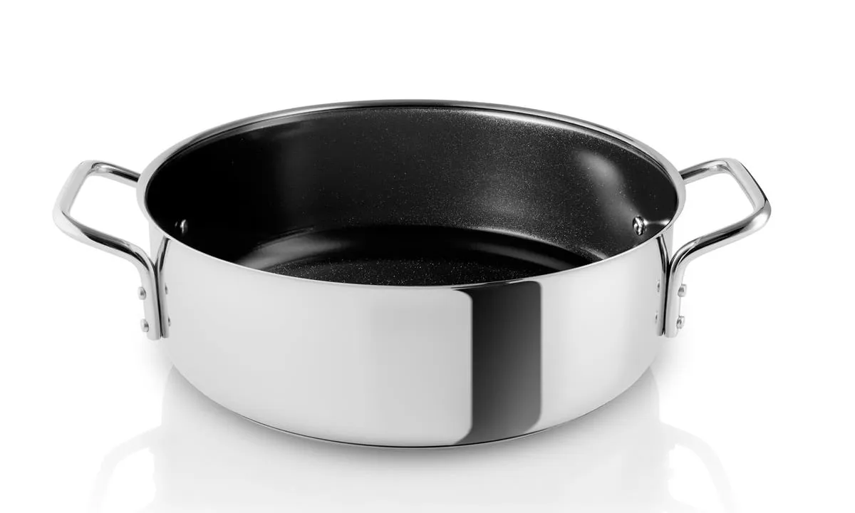 Stainless steel pot with a light-colored ceramic cooking surface.