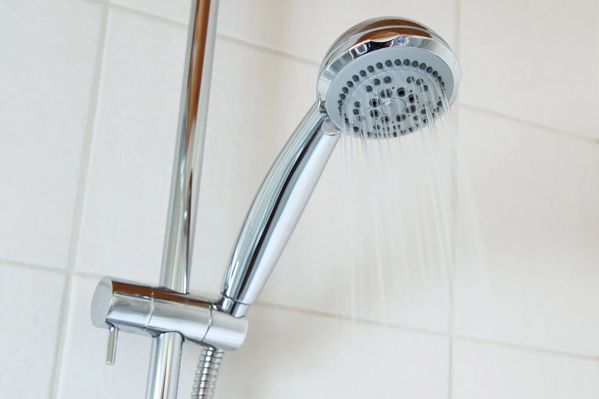 A stainless steel shower caddy holding bottles in a bathroom