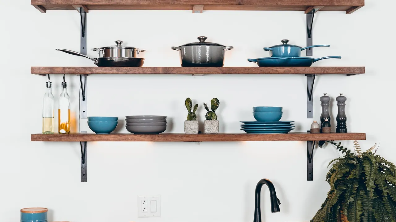 Cookware arranged on open shelves above a kitchen sink