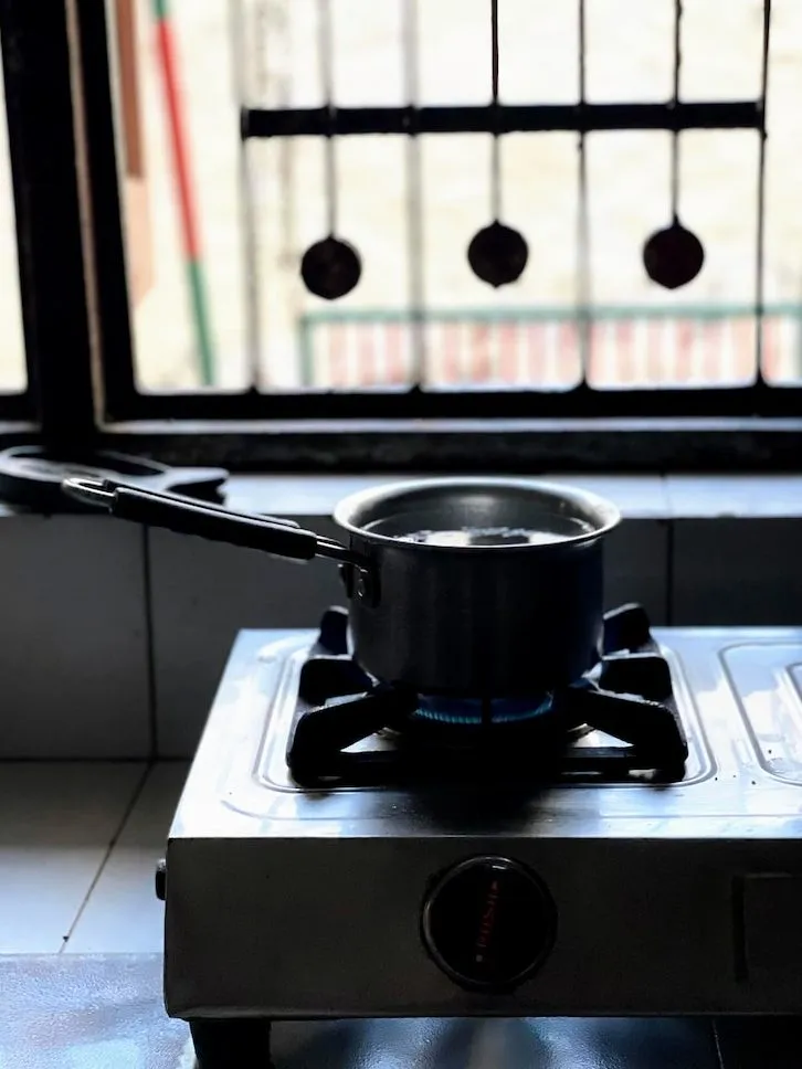 a stove top sitting on top of a counter next to a window