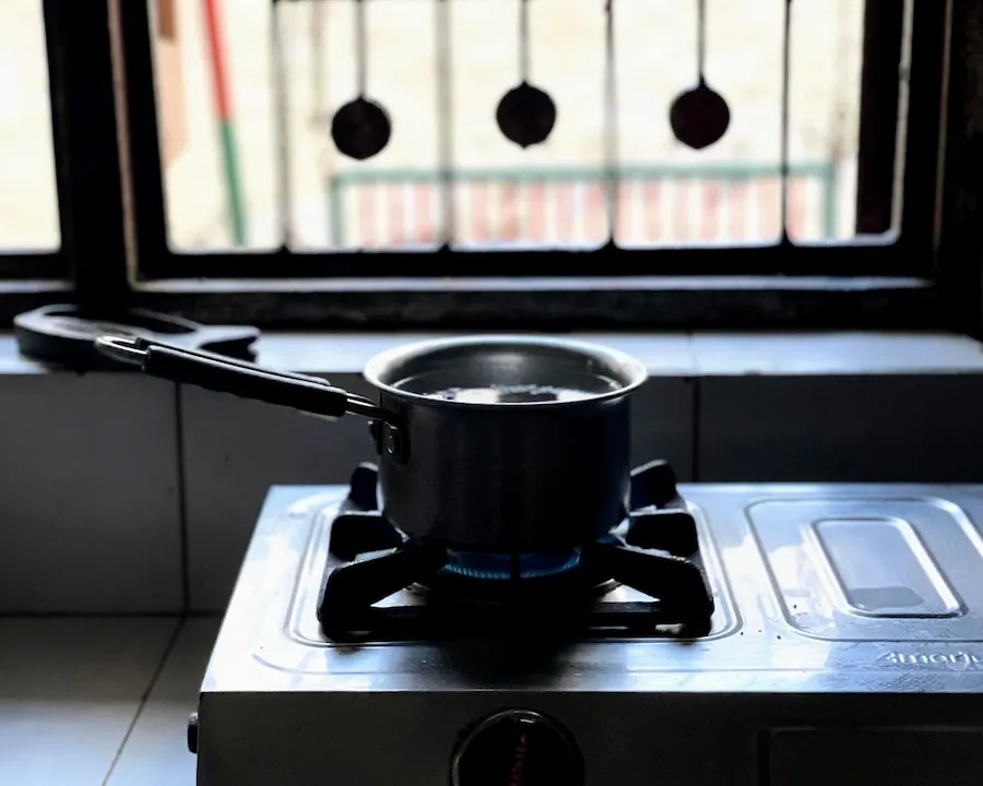A small saucepan heating over a blue gas flame