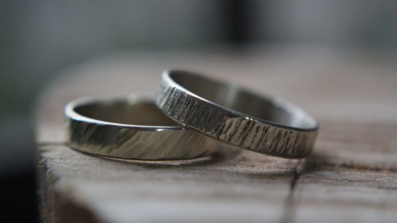 Two silver-colored rings resting on a wooden surface