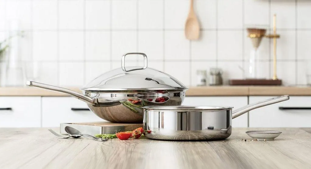 Stainless steel pots arranged on a kitchen counter.