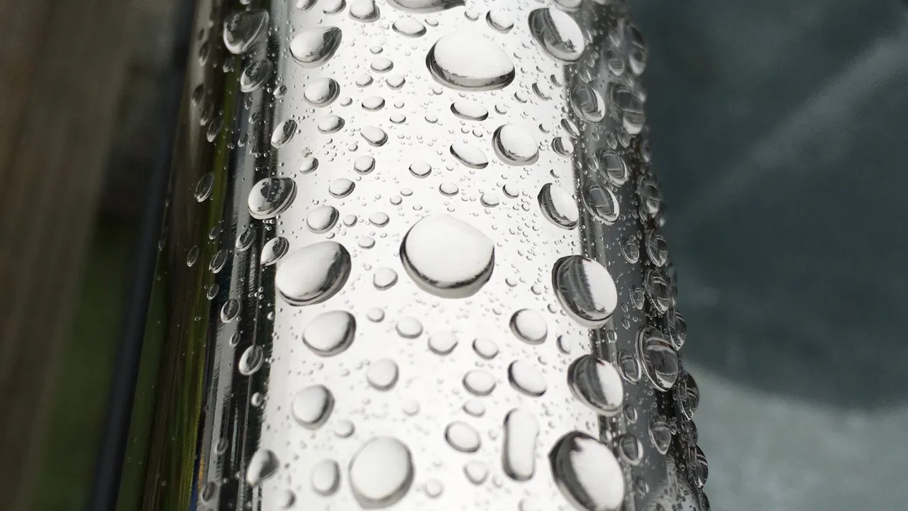 Water droplets beading on a brushed stainless steel surface