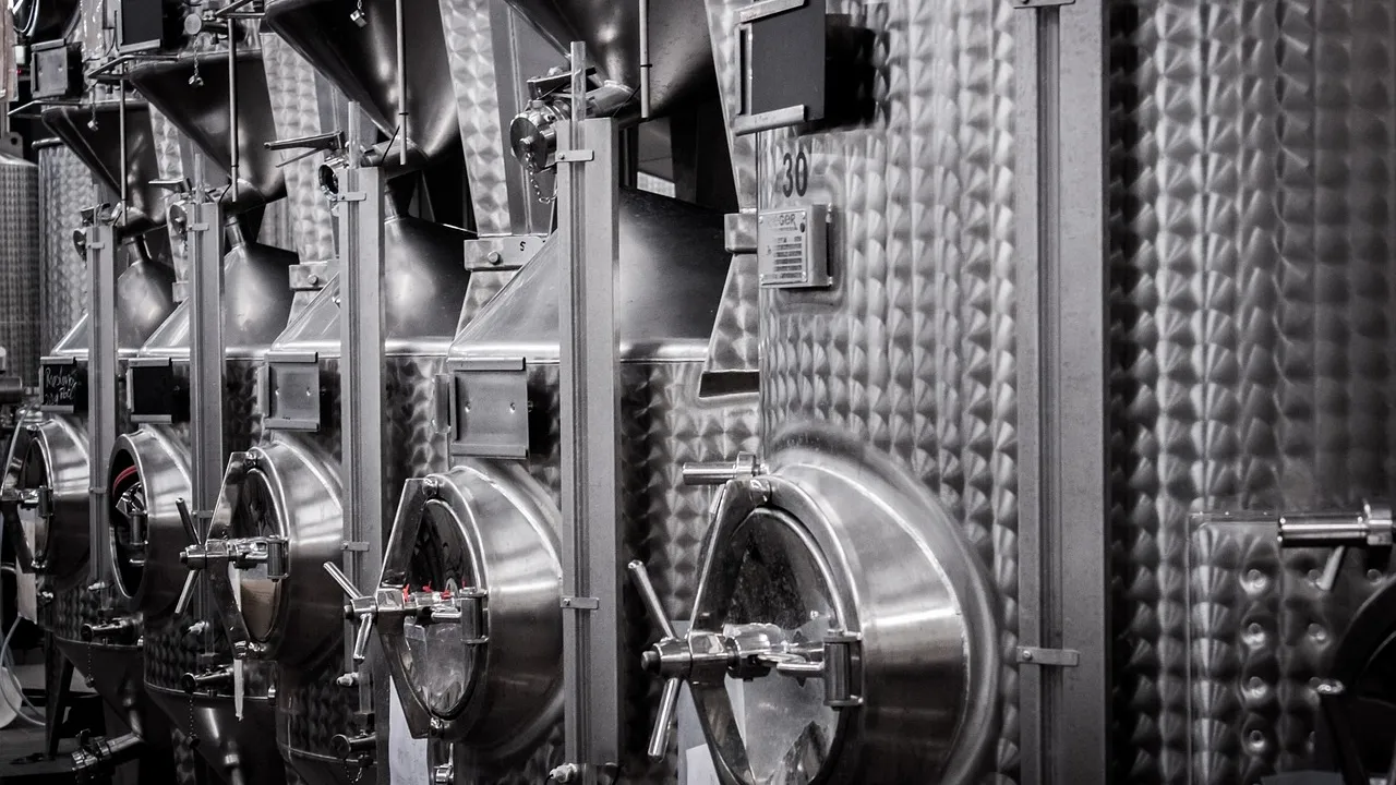 Rows of stainless steel fermentation tanks in an industrial facility